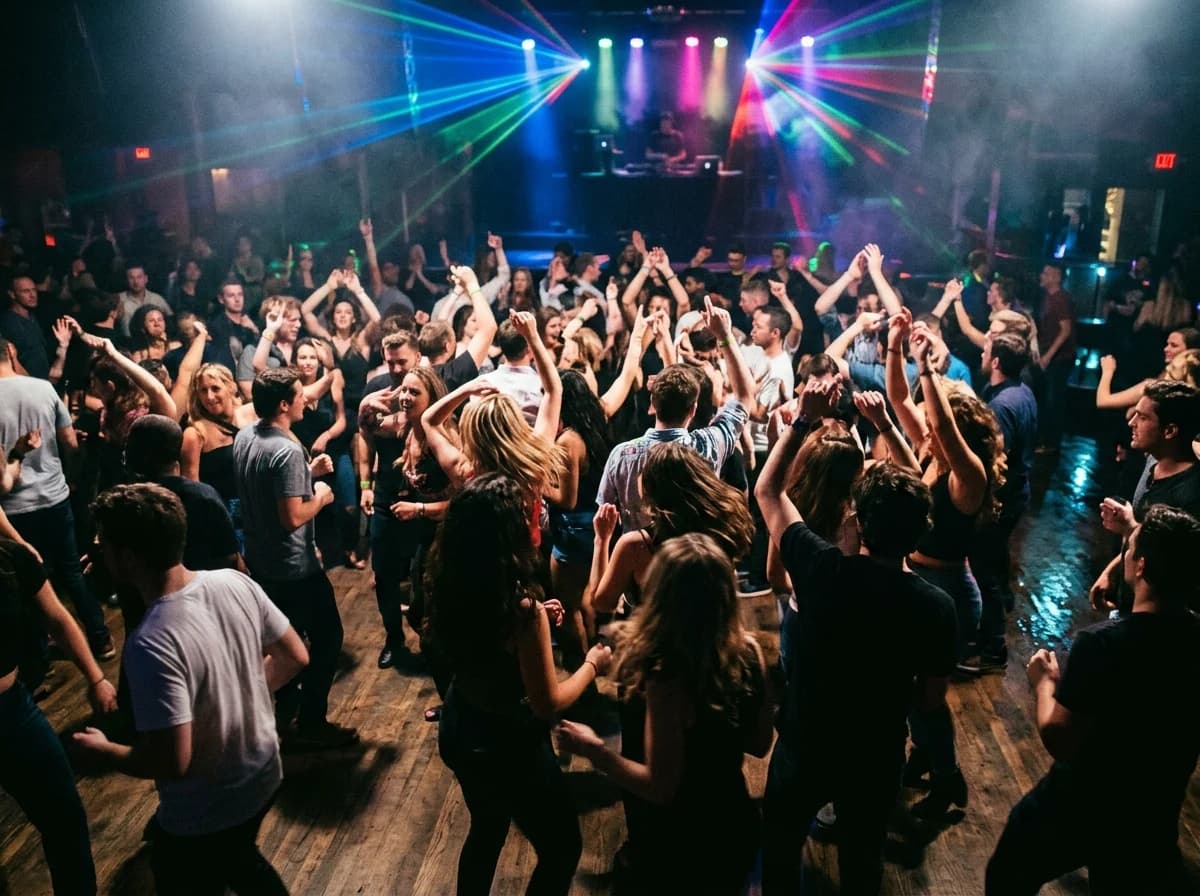 Blurred, energetic crowd dancing under vibrant club lights.