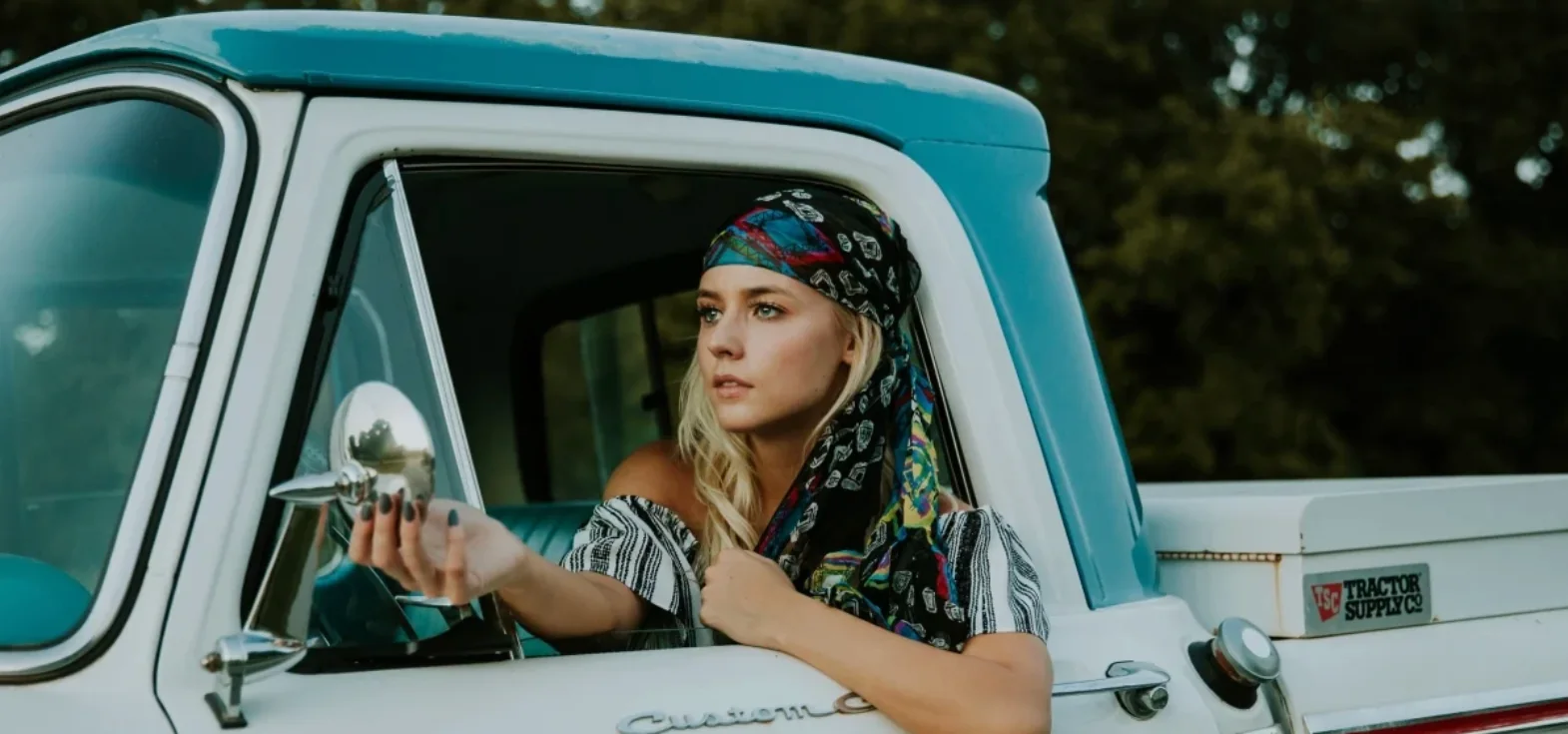 A woman in a turquoise vehicle, from The Fashionista Fable published blog example